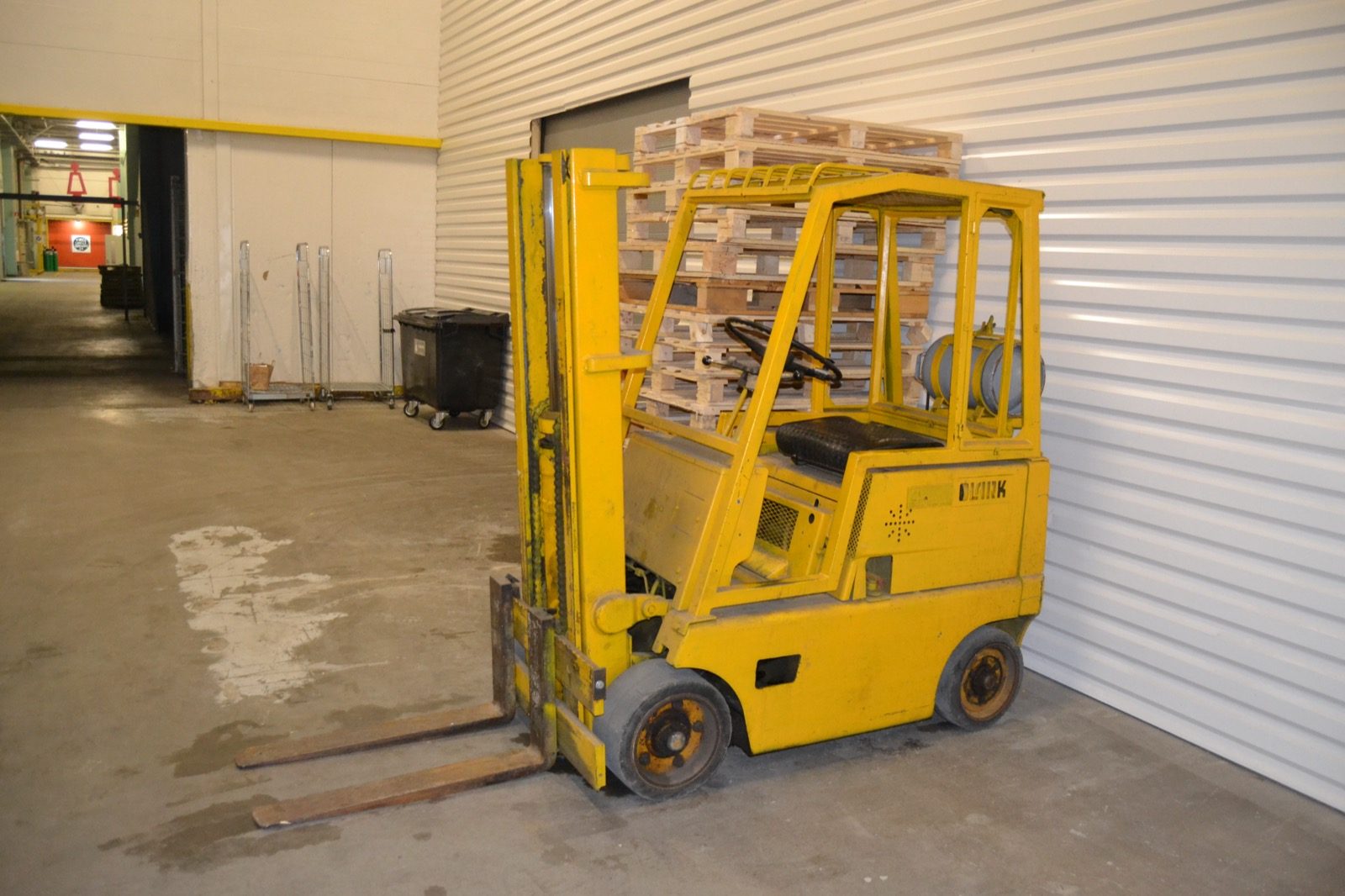 A forklift on a shop floor inside a large hall.