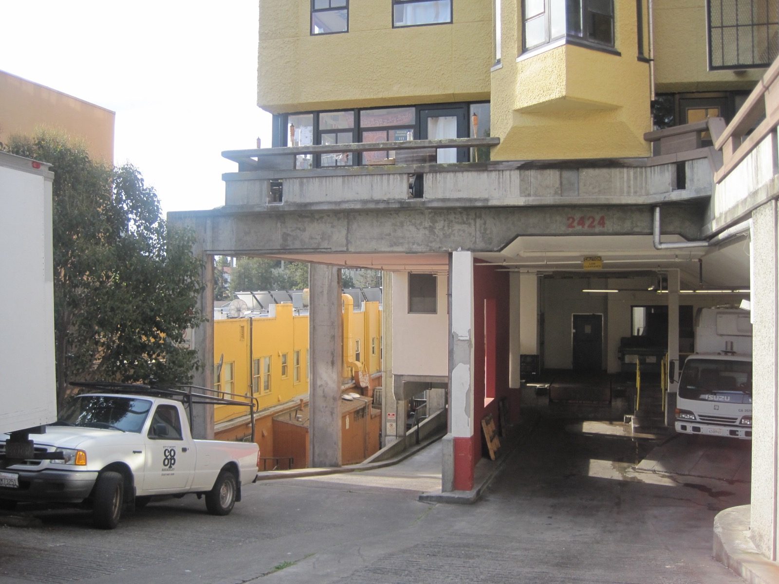 A loading dock with roll-up doors and parked vehicles.